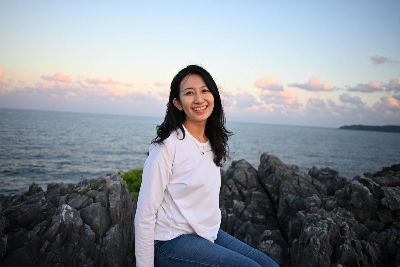 海辺の岩場でほほえむ新婦